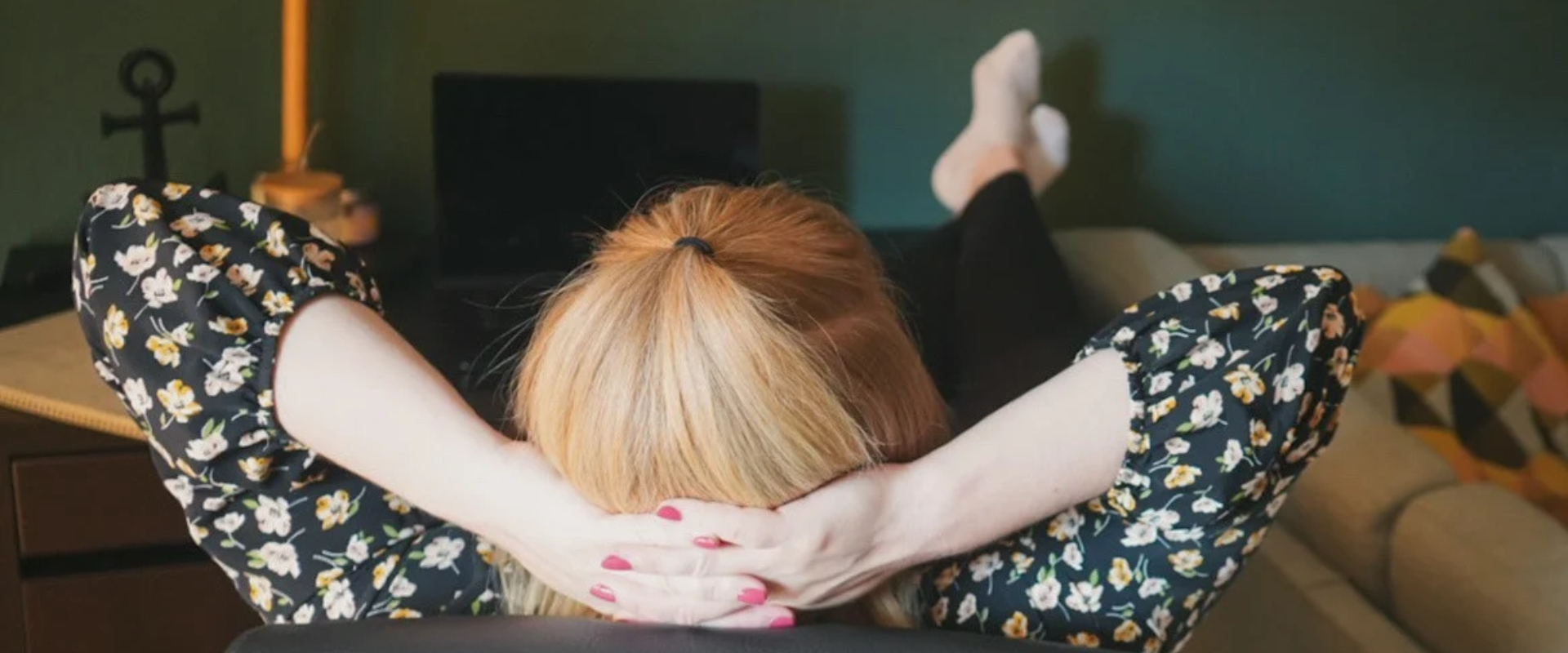 Maren Thiel, Social Media Managerin aus Nordfriesland, lehnt entspannt am Schreibtisch zurück, Hände hinter dem Kopf verschränkt